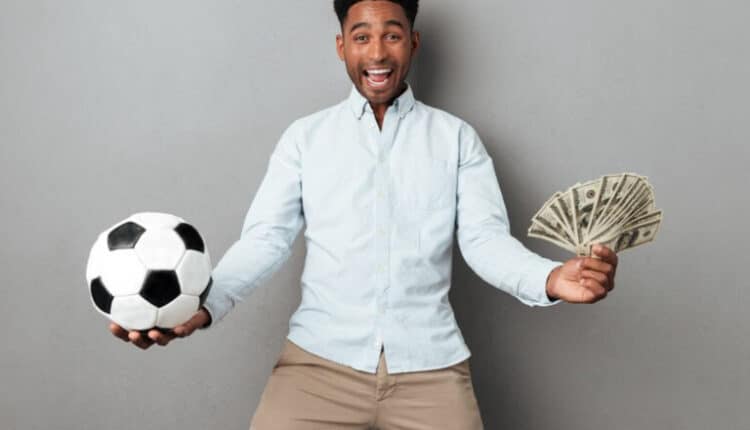 Homem feliz segurando notas de futebol e dinheiro